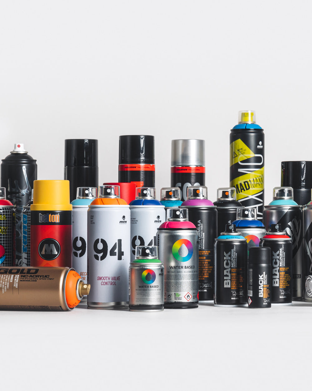 A variety of spray cans and other graffiti cans neatly arranged together.