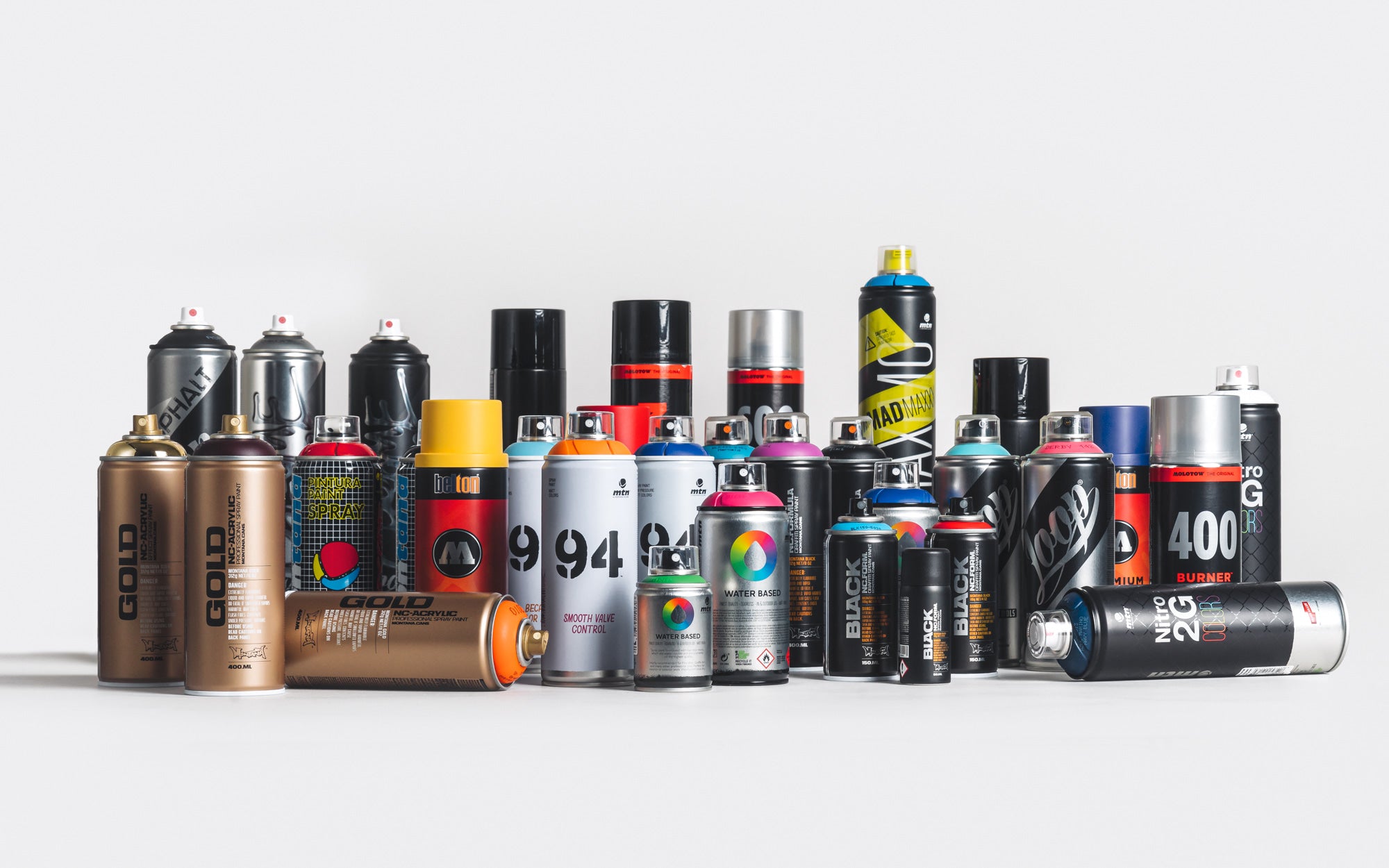 A variety of spray cans and other graffiti cans neatly arranged together.