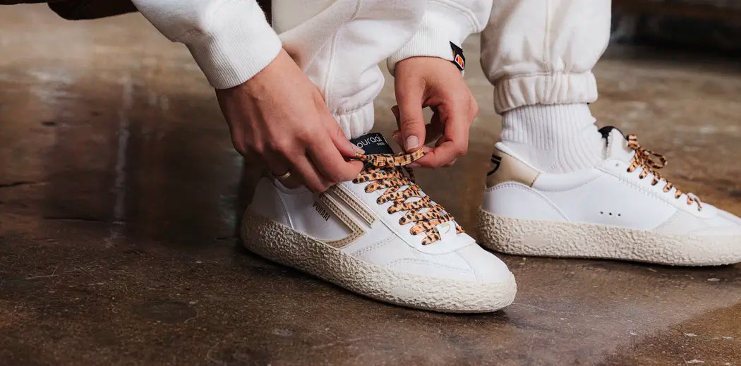 White sneakers with brown accents, vegan and leather-free, perfect for women's casual style.