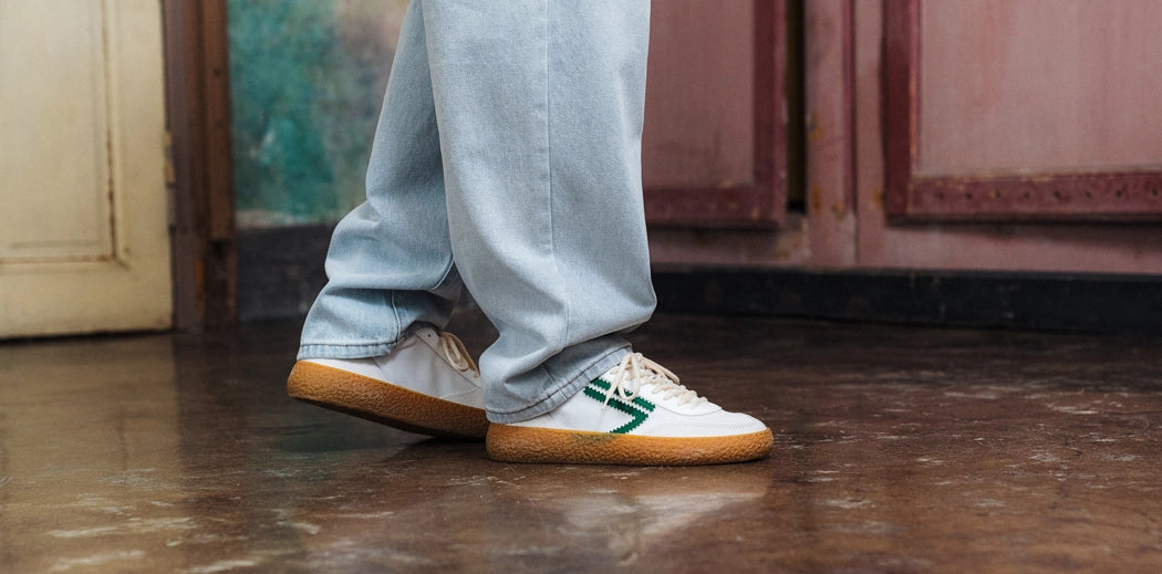 Men's vegan sneakers in white worn with jeans by a guy.