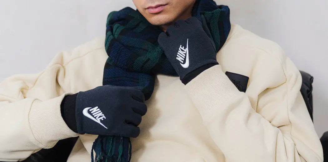 Men's winter accessories worn by a guy: gloves and scarves in various styles and colors.