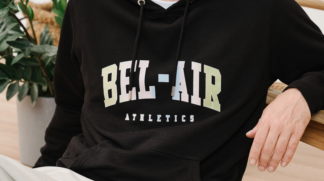  A man in a black hoodie with 'Bel-Air' on it by Bel Air Athletics.