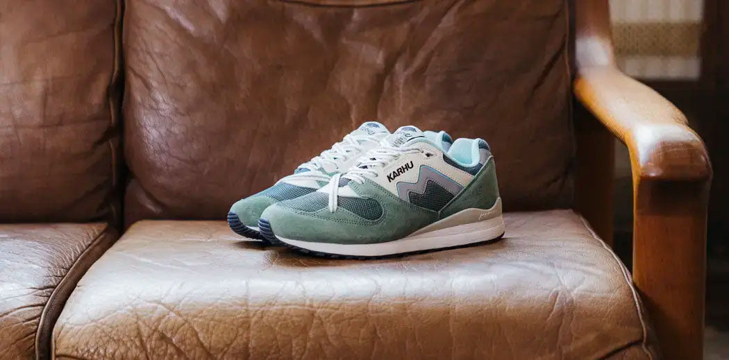 A pair of Karhu sneakers placed on a couch.