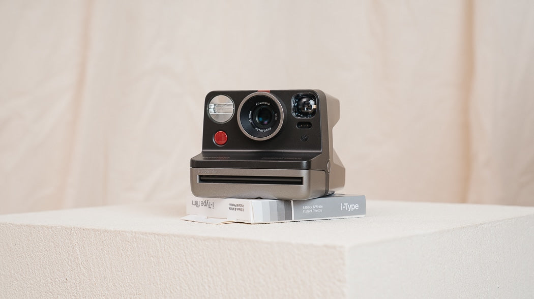 A Polaroid camera placed on a box.