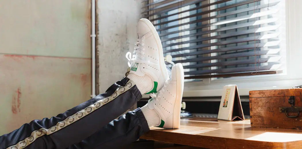 Iconic adidas Stan Smith shoes in white with green details.