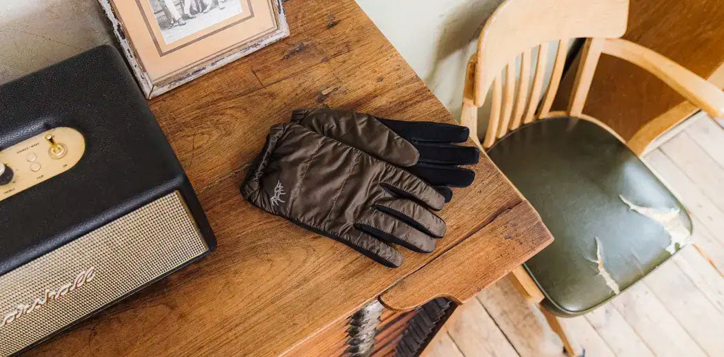 Elmer by Swany brown gloves with black lining placed on a table.