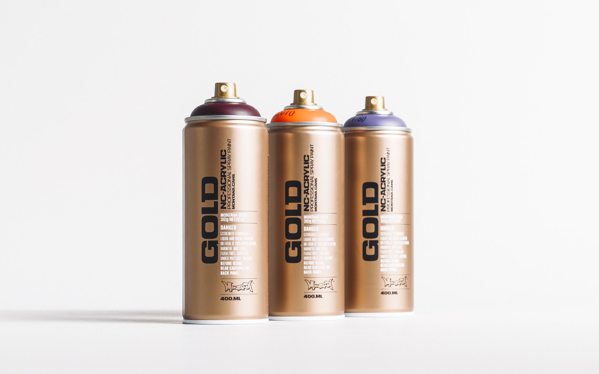 Three gold Montana spray paint cans